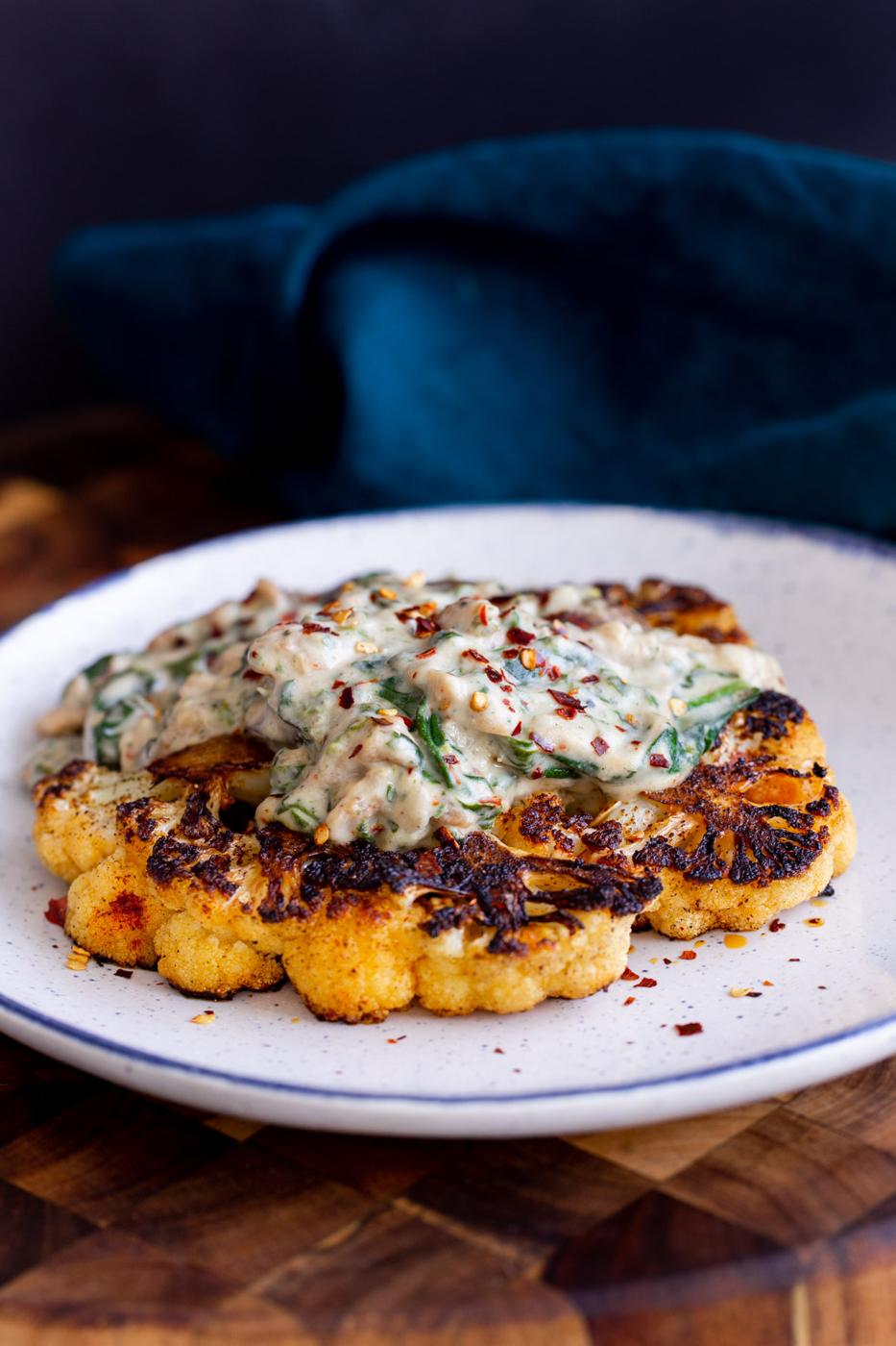 soycurl florentine served on a cauliflower steak on a white plate