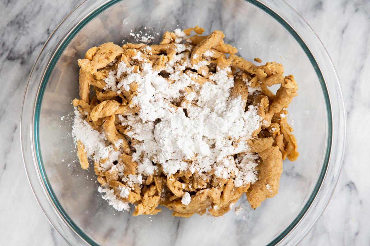 soaked soy curls being coated with cornstarch