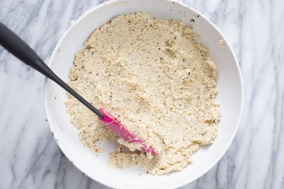 mixture for vegan croquettes being mixed in a white bowl