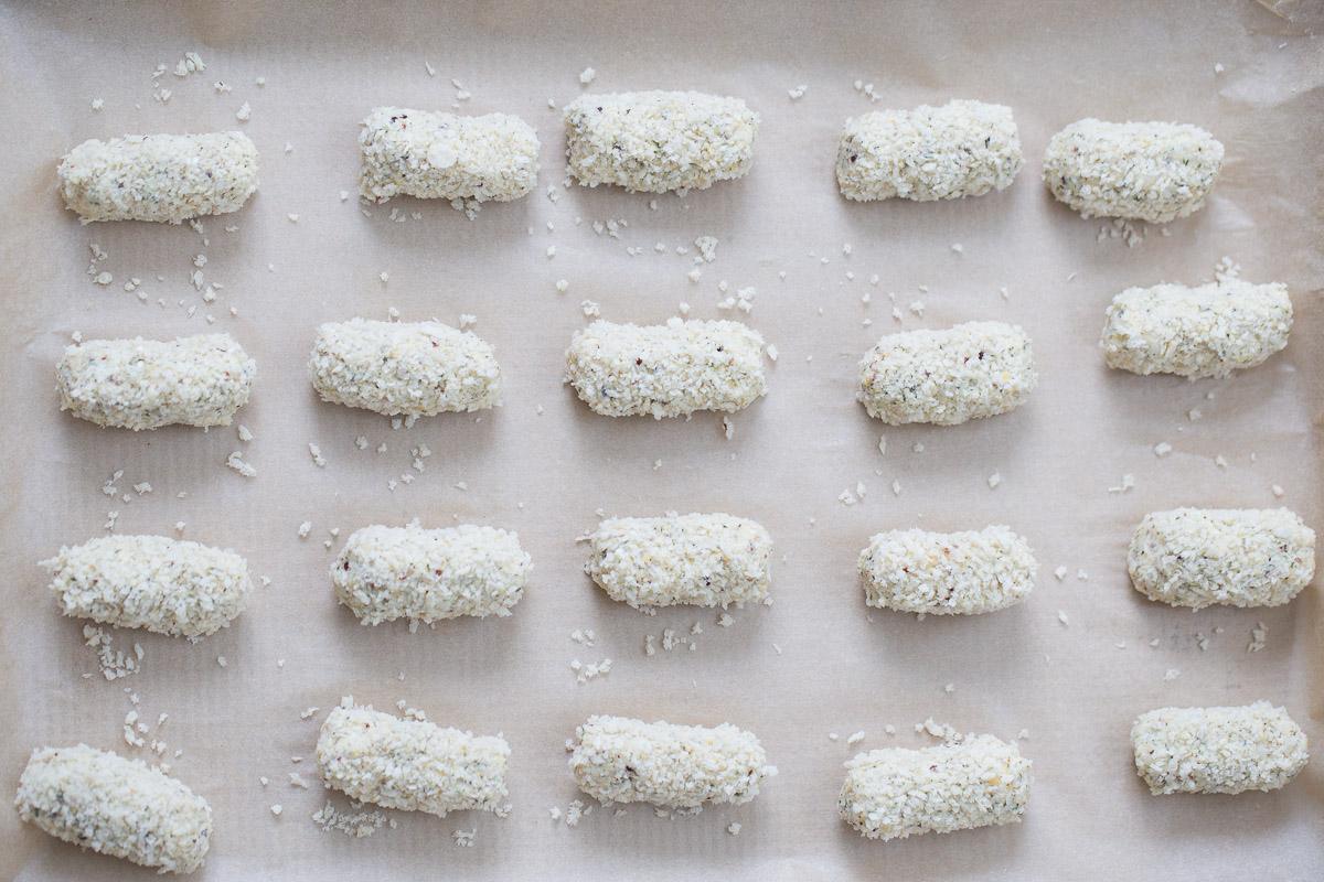 unbaked vegan quinoa chickpea croquettes rolled in breadcrumbs on a baking sheet