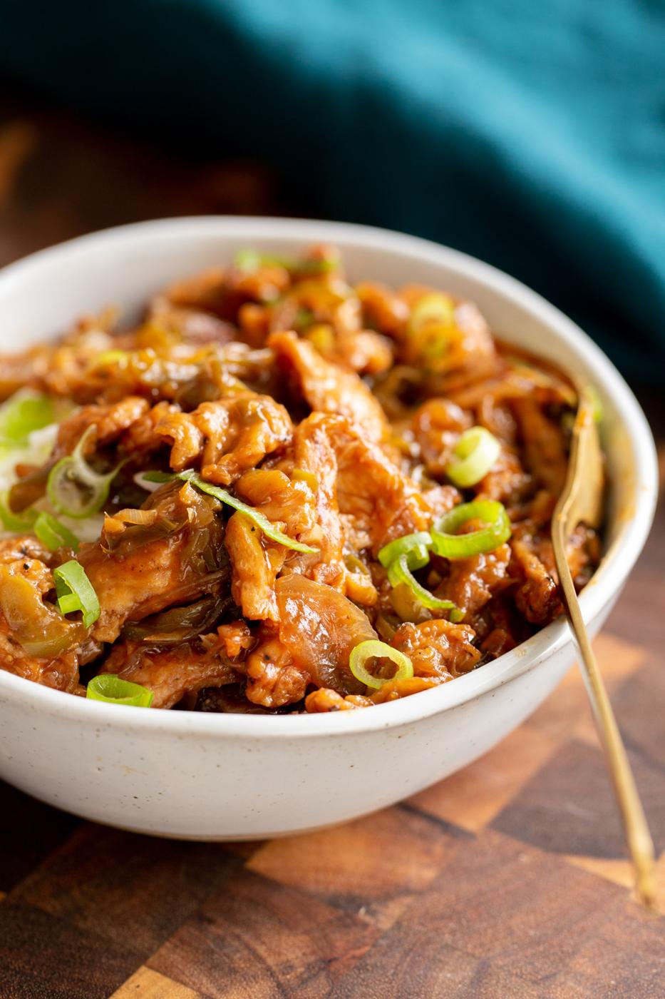 side view of vegan soy curl chilli chicken in a white bowl
