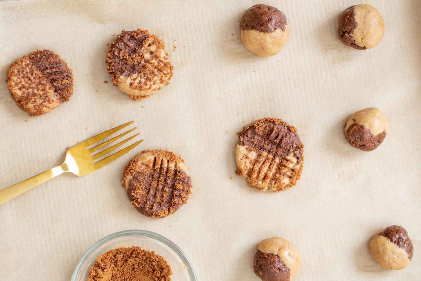 vegan pumpkin spice snickerdoodle cookies being placed on a cookie sheet before baking