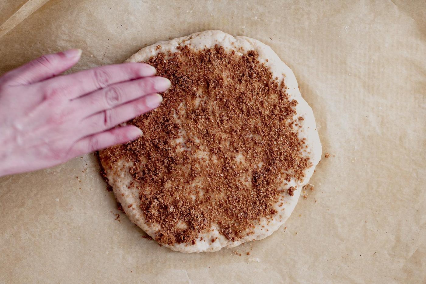 cinnamon sugar being sprinkled on biscotti dough to make churro biscotti