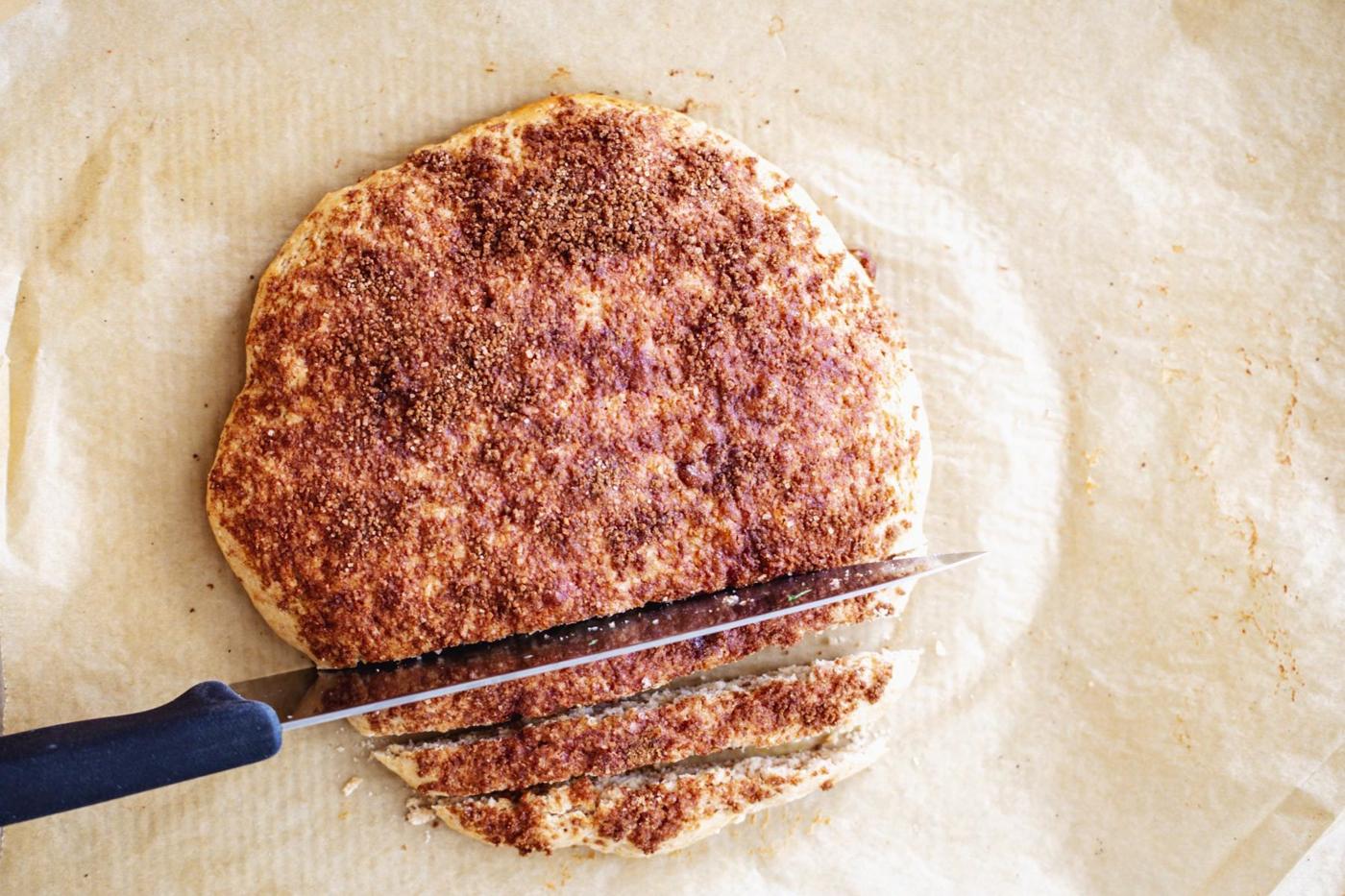 baked vegan biscotti loaf being sliced into cookies