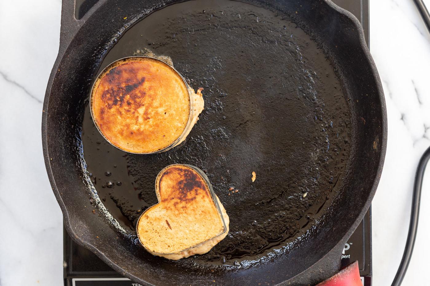 Vegan Cinnamon Streusel Pancakes getting cooked on a cast iron skillet