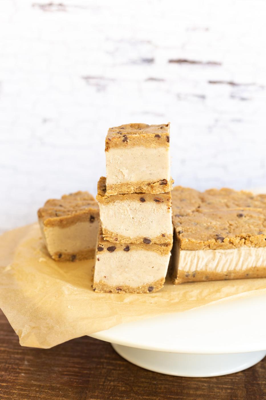 Vegan Cookie Dough Ice Cream Sandwiches stacked on a white cake stand