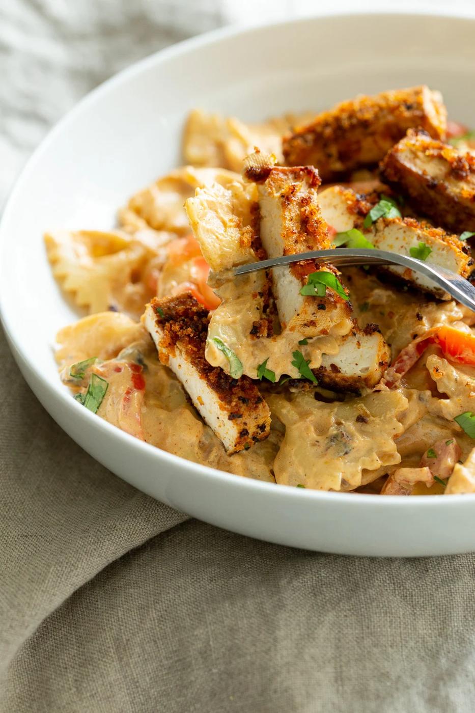 Vegan Creamy Cajun Pasta with Crisp Breaded tofu in a white bowl
