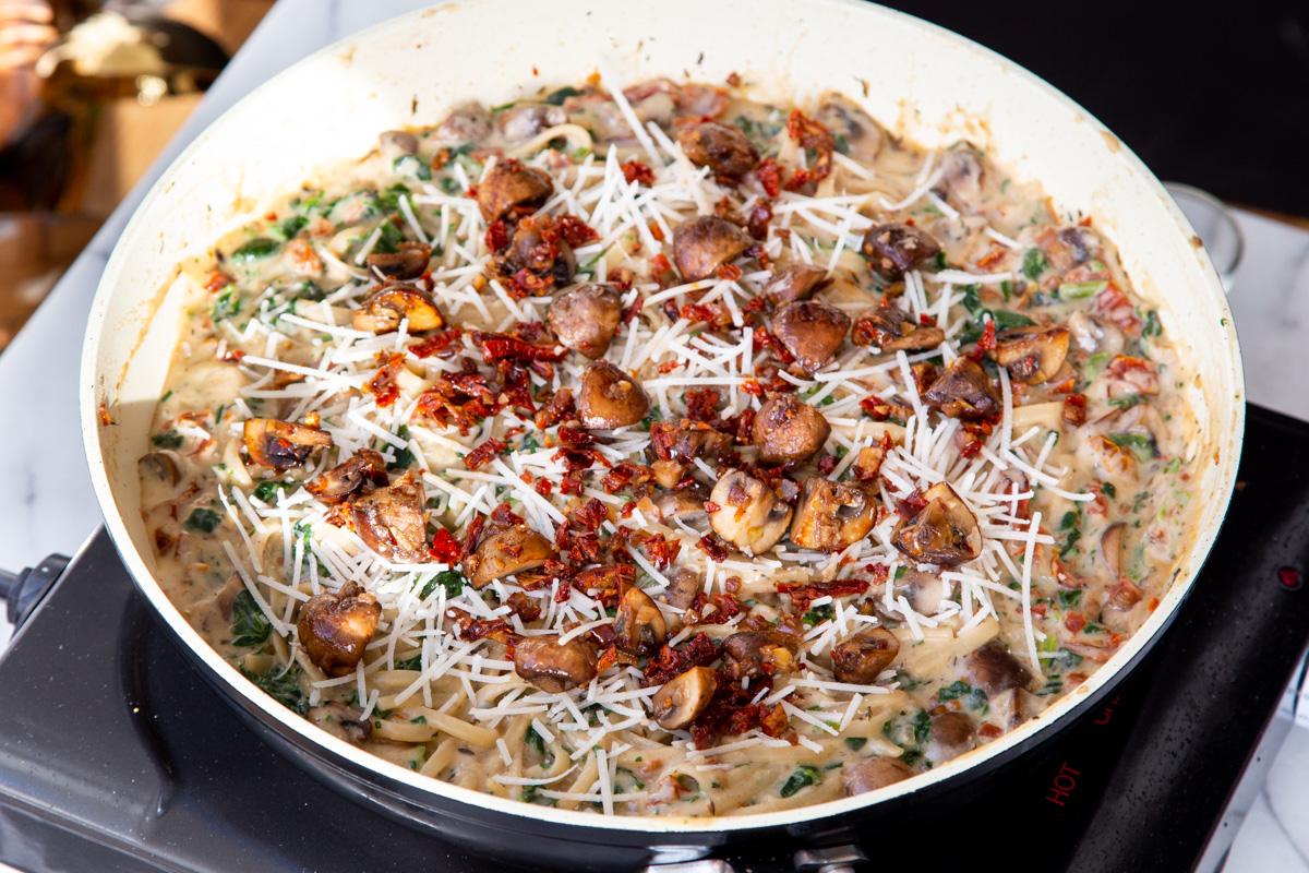 mushroom spinach and sundried tomato pasta in a saucepan
