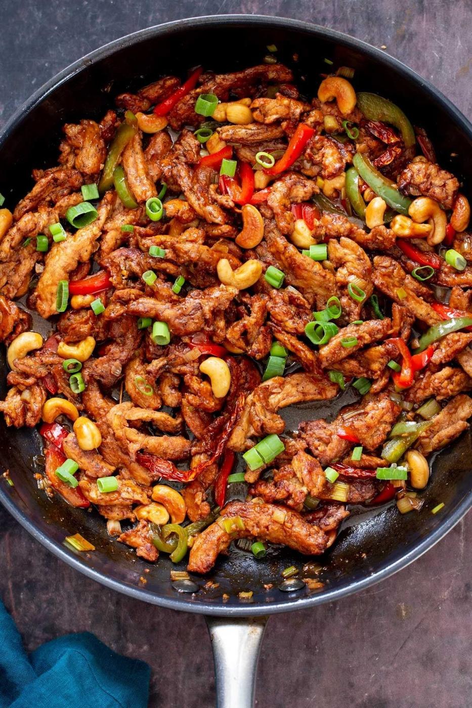 chopped spring onions sprinkled over soycurls in a sauteeing pan