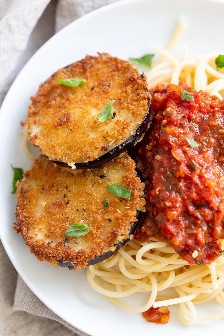 Vegan Eggplant Parmesan with spaghetti in white plate
