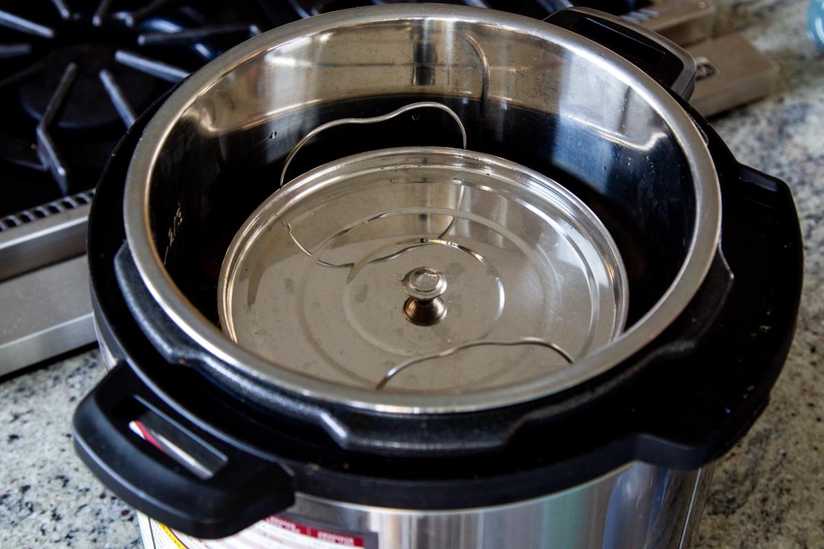 small silver pot being lowered into an Instant Pot