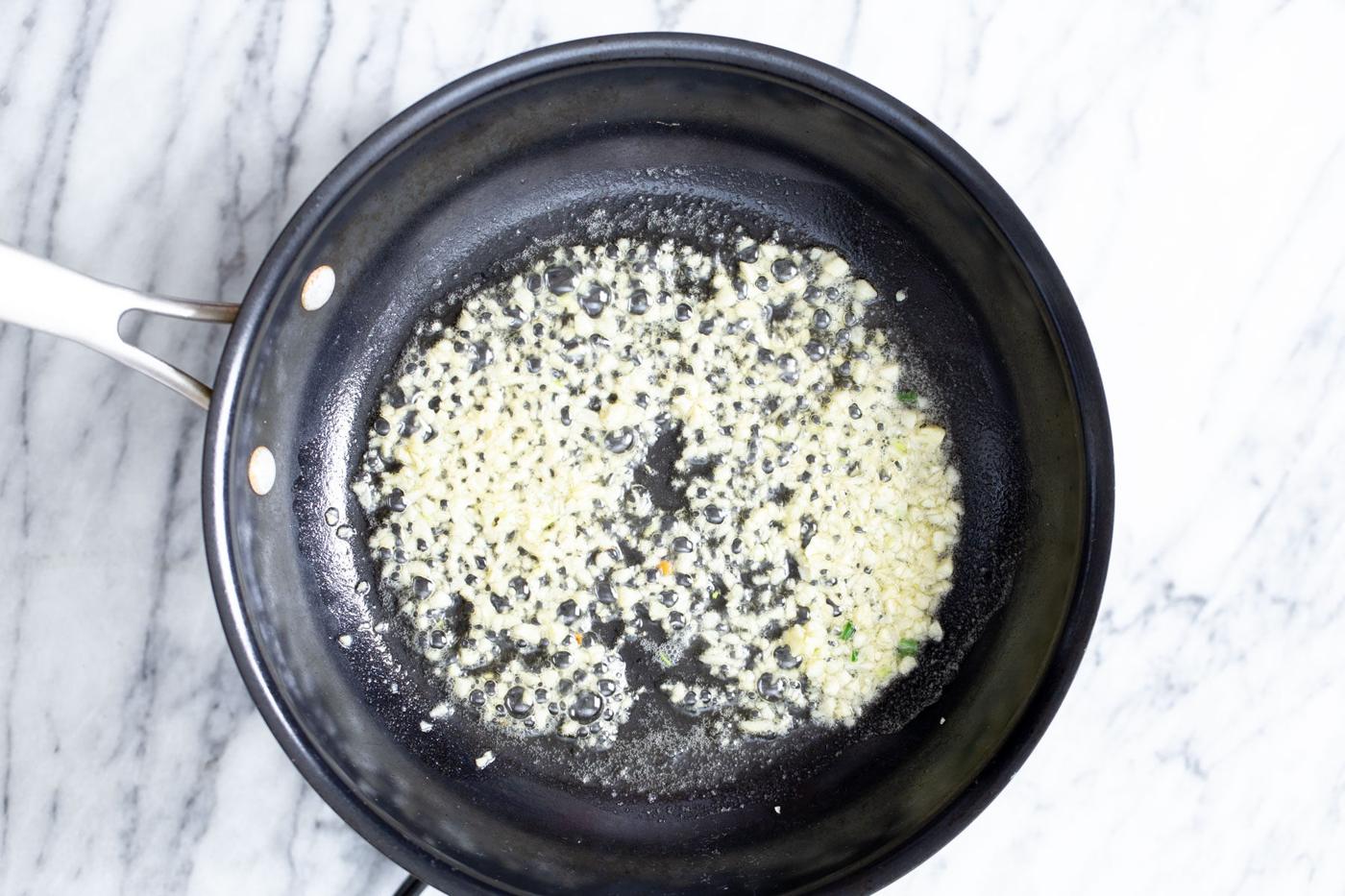 garlic being fried in a pan