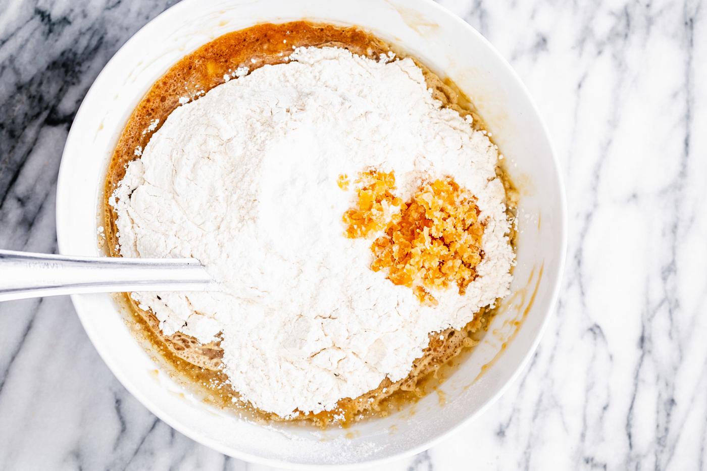 flour being added to wet batter ingredients