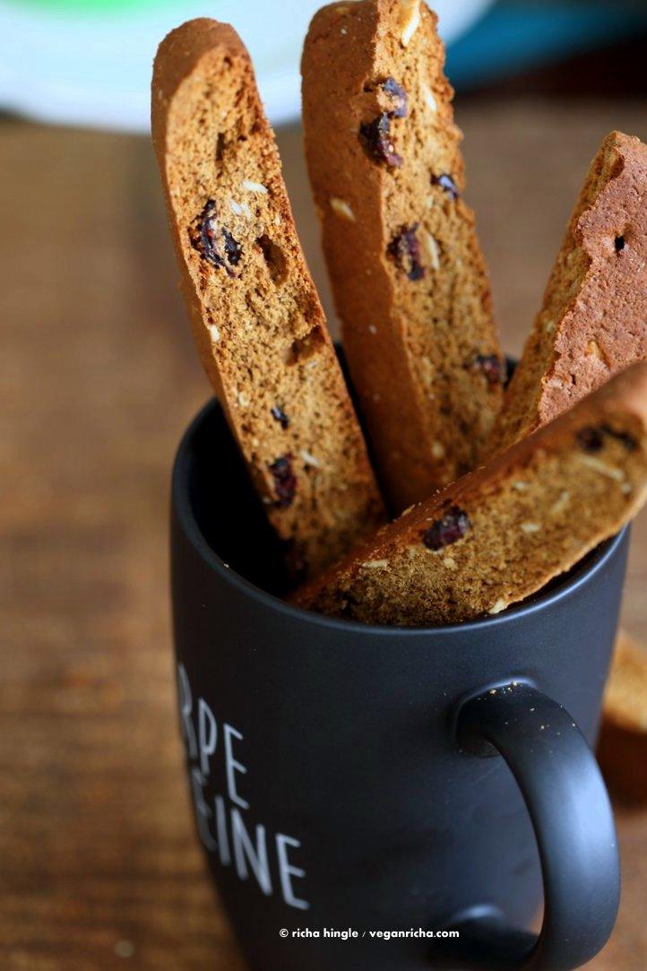 Vegan Gingerbread Biscotti with cranberries, almonds, candied ginger. Easy Crispy Spiced Biscotti Recipe to dunk in a cup of tea. Drizzle with white or dark chocolate. | VeganRicha.com #vegan #gingerbread #biscotti #recipe