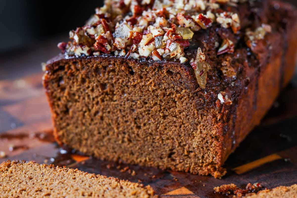 gingerbread cake on a cutting board with a slice cut out