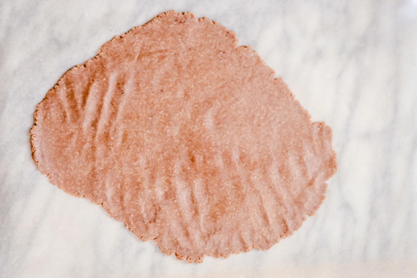 vegan gingerbread cookie dough rolled out on a marble countertop