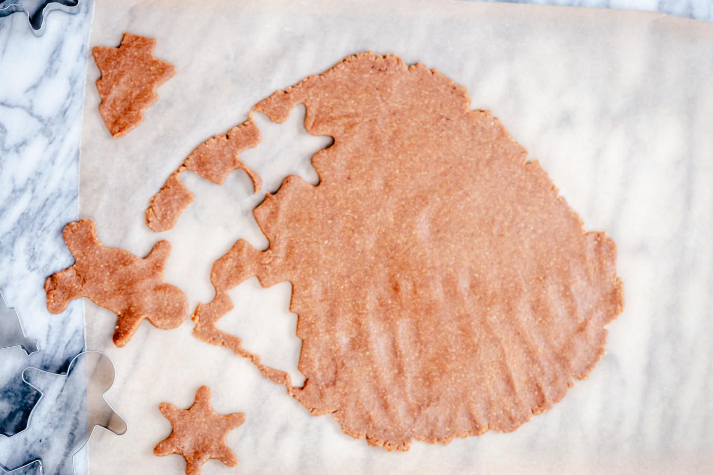 glutenfree cookie dough being but out using a star shaped and a gingerbread cookie cutter