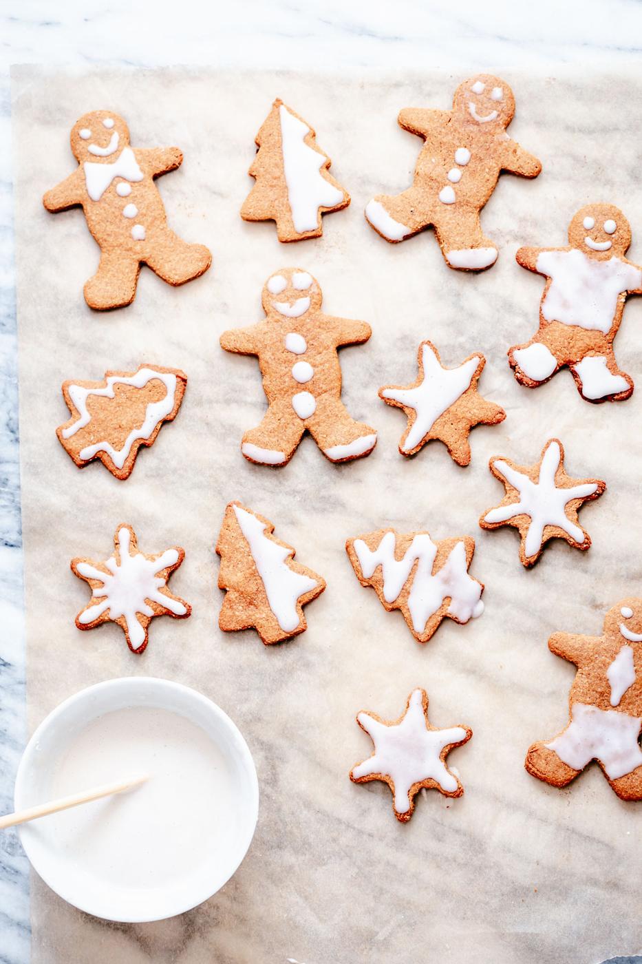 overhead shot of vegan gingerbread cookies being iced