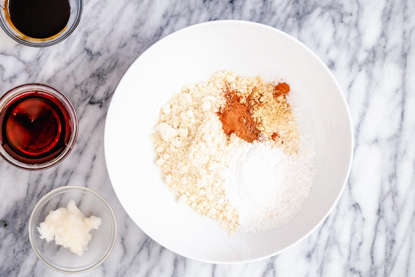 a small bowl with gluten-free flour and spices used for making vegan gingerbread cookies
