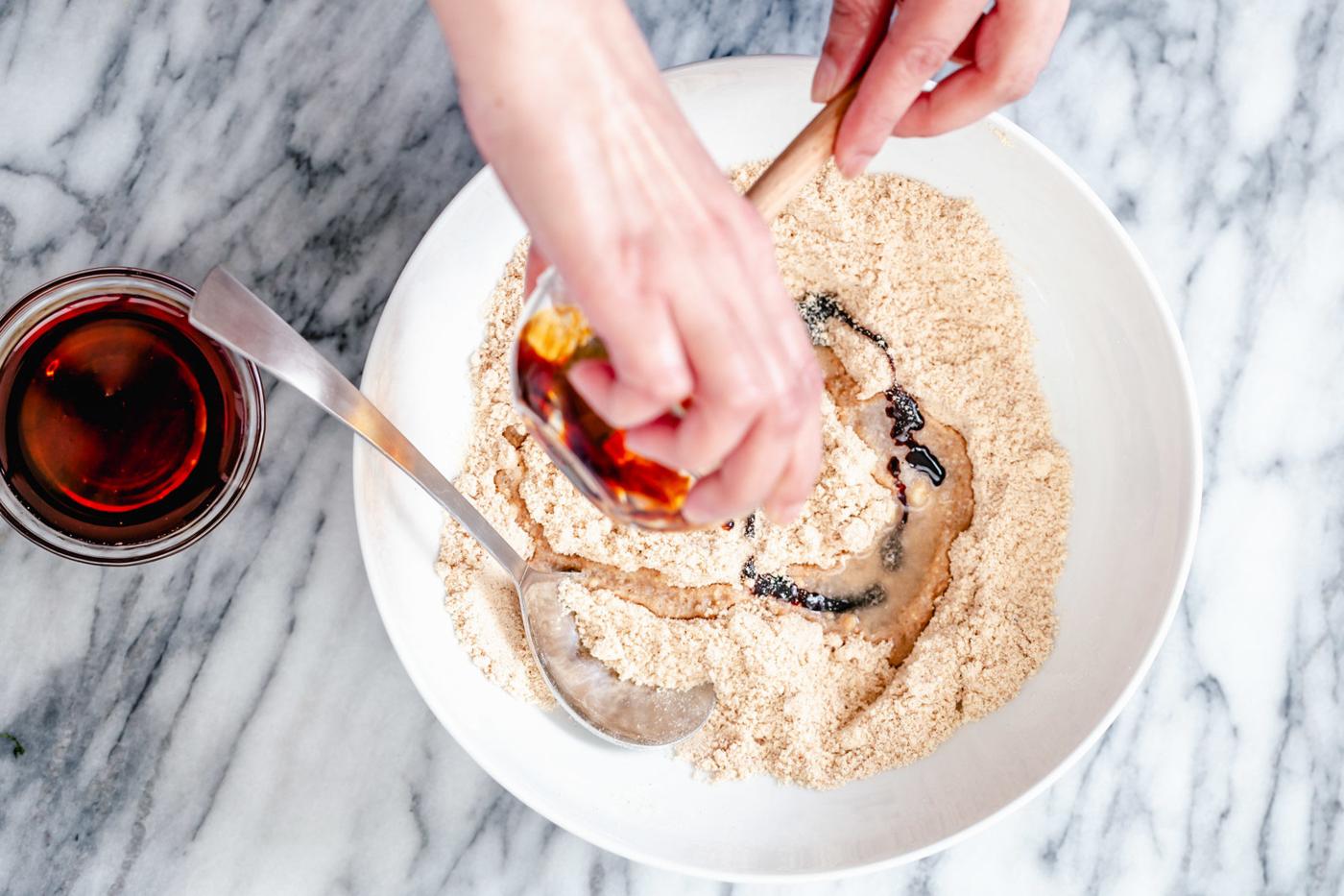 maple syrup and coconut oil being added to gluten-free flours for making vegan gingerbread cookies