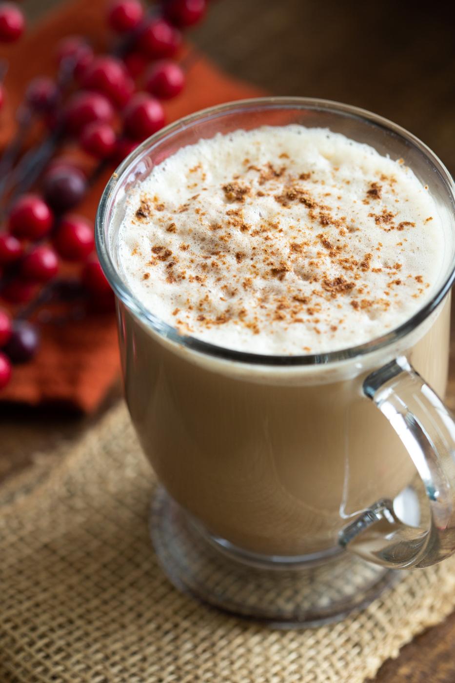 Creamy Vegan Gingerbread Latte in a glass mug placed on wood table