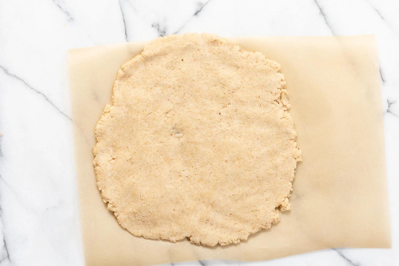 Dough of our Vegan Gluten free Cinnamon Rolls rolled out on parchment