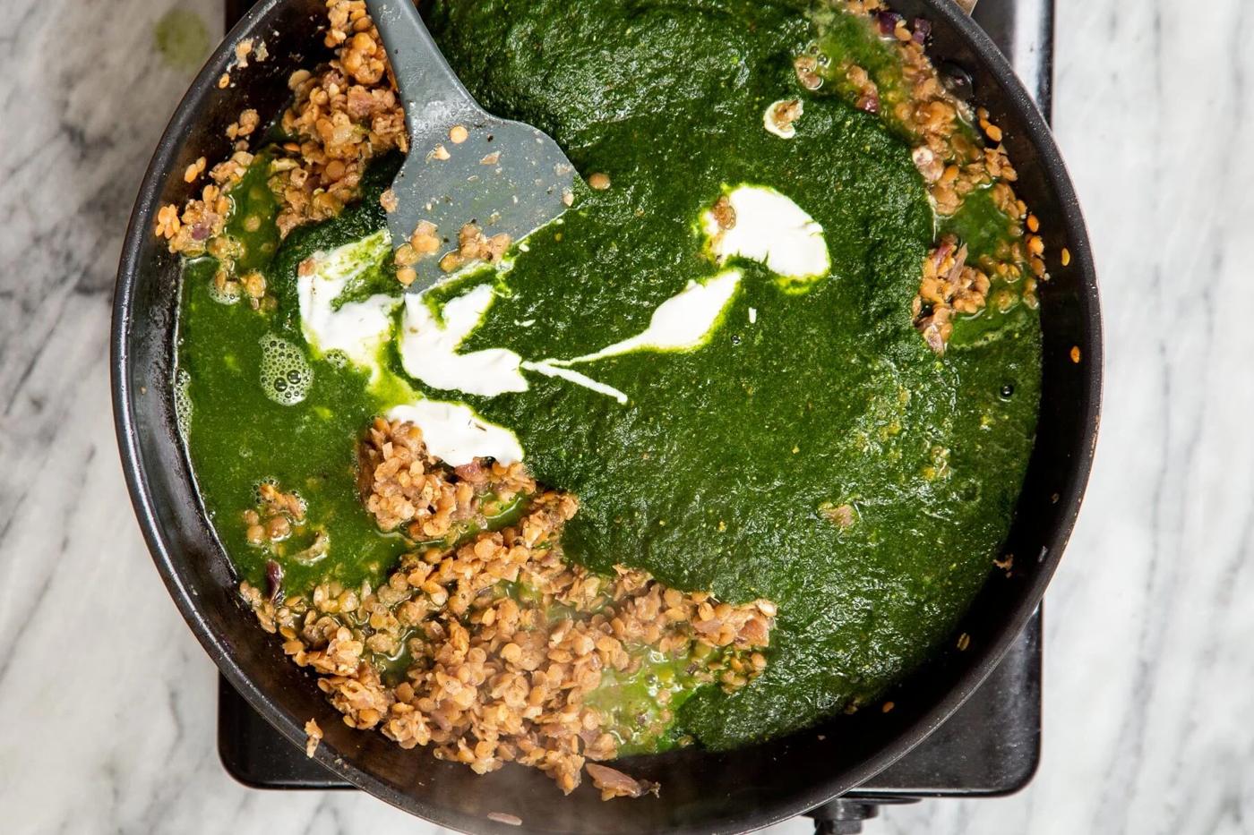 yogurt, herb sauce and red lentils in a black skillet