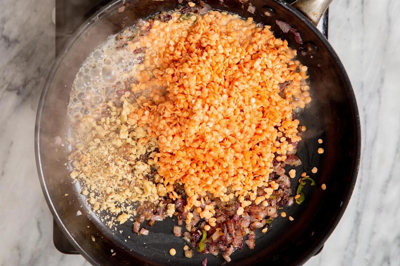 red lentils sauteed onions and walnuts in a black frying pan