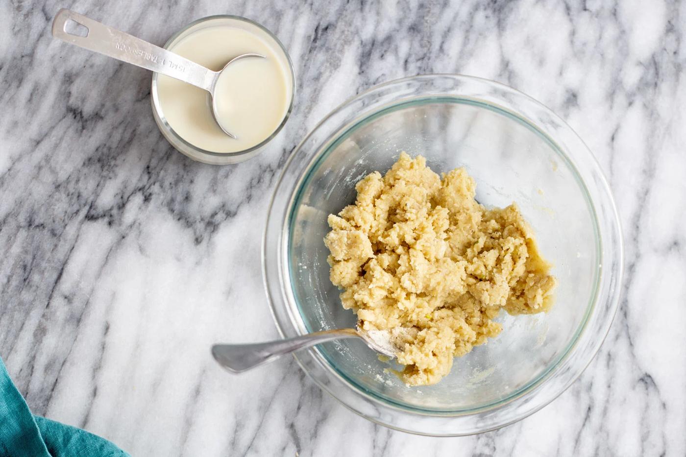 milk being added to donut batter for making vegan gulab jamun recipe