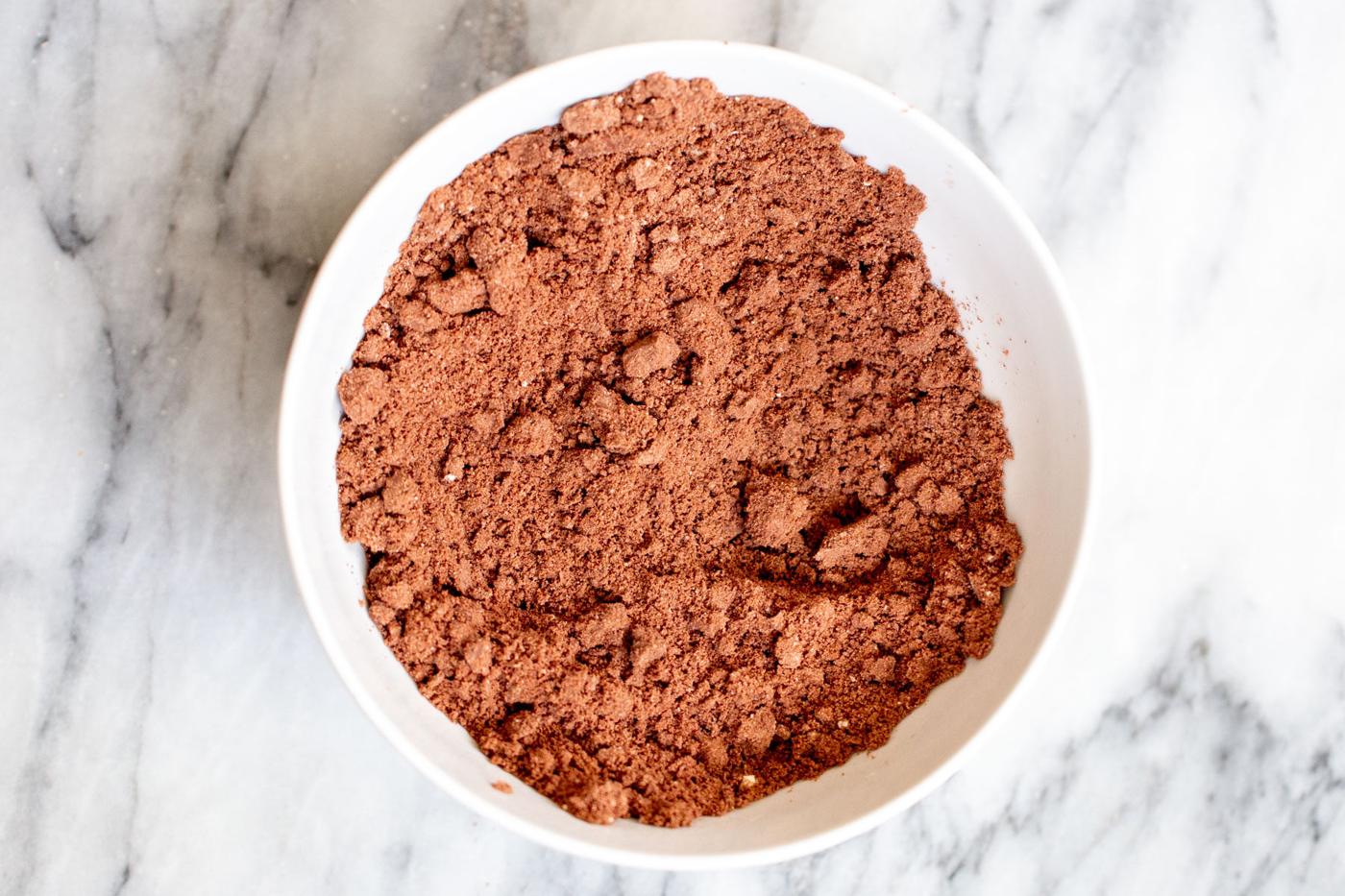 mixed dry ingredients for vegan hot chocolate mix in a white bowl
