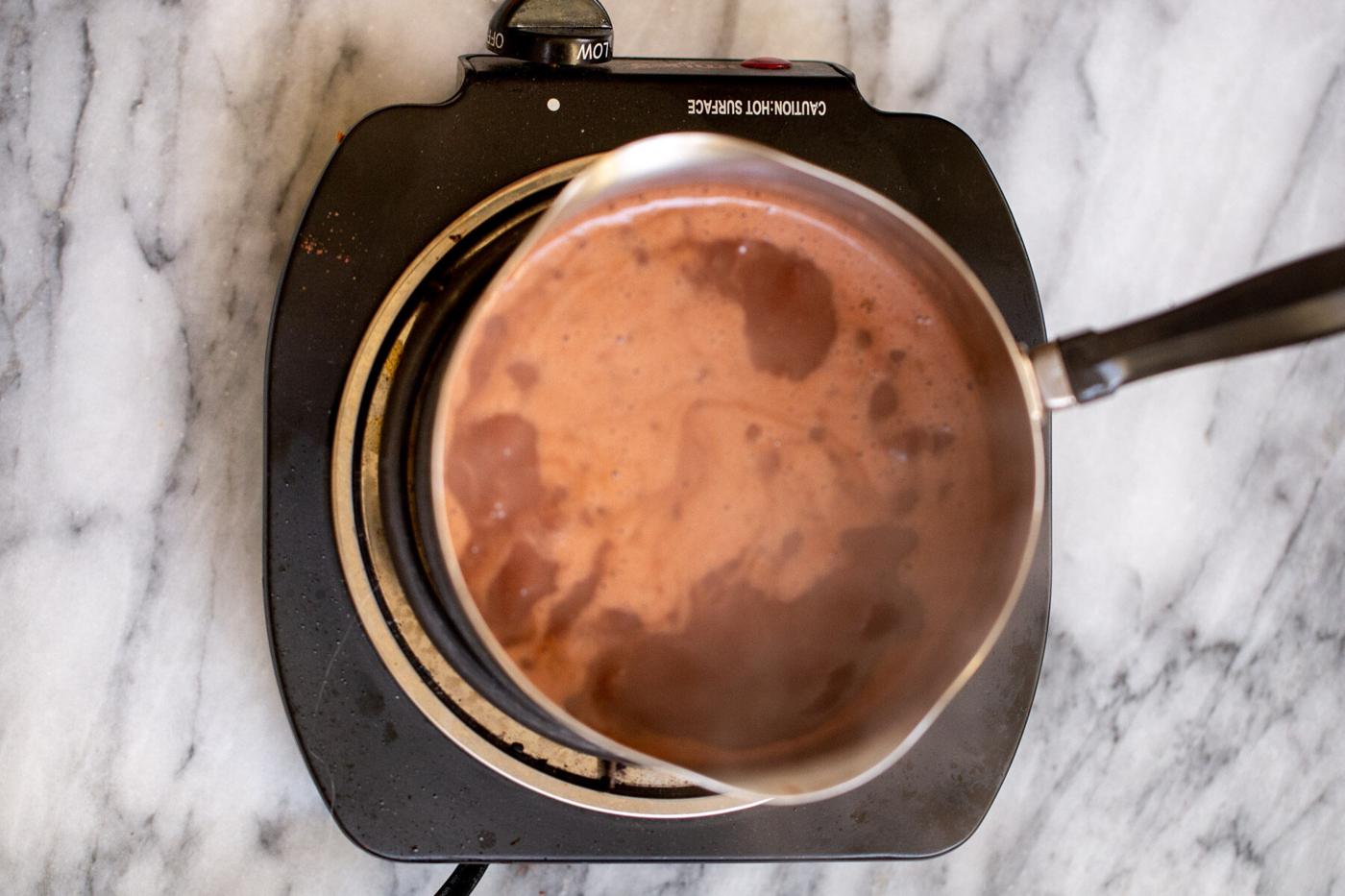 a small saucepan with vegan hot chocolate on a cooking plate