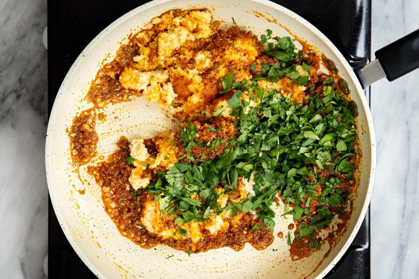 ground ural dal, cilantro and spice blend in a sauteeing pan