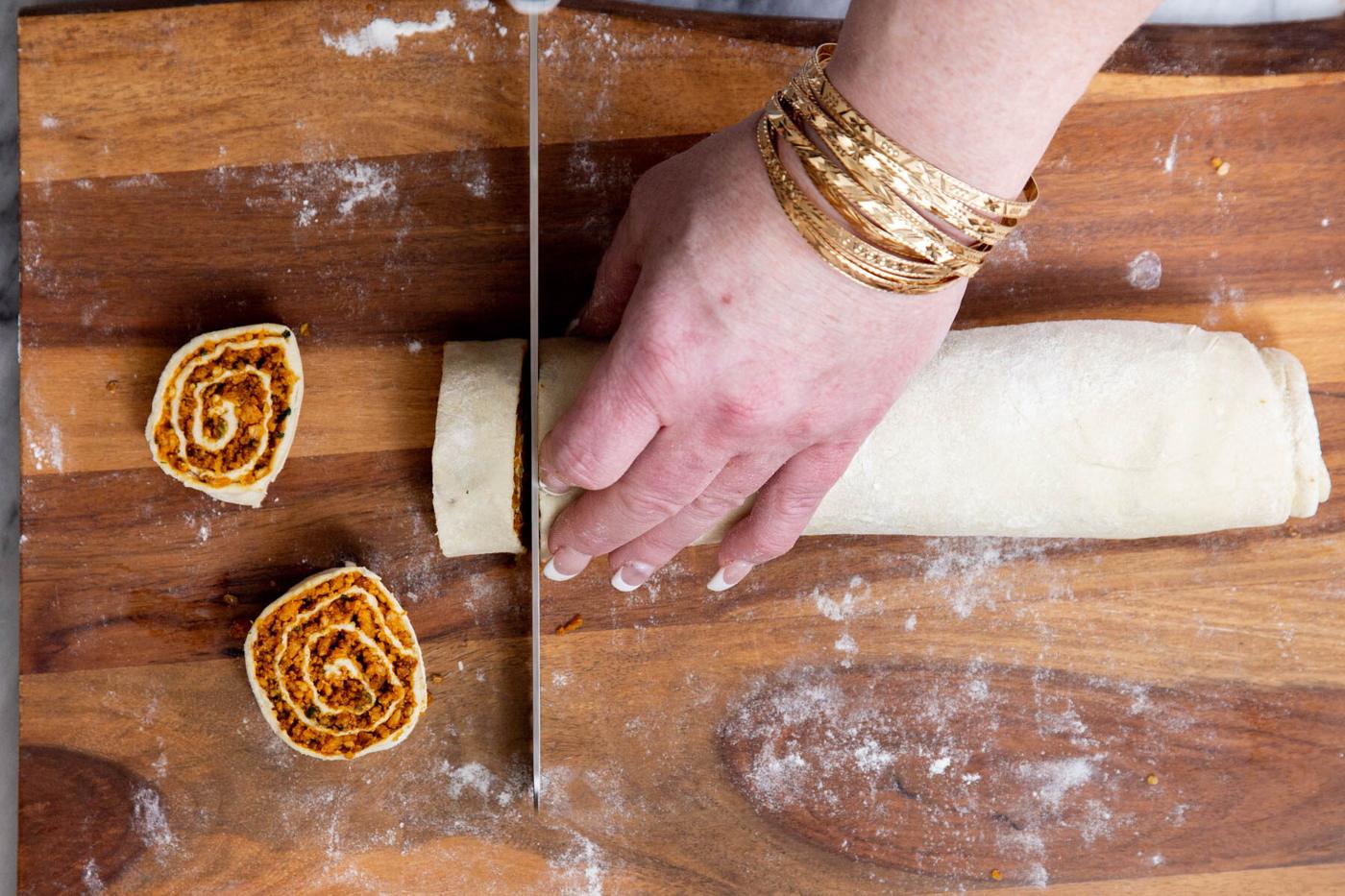 vegan pinwheels being cut on a chopping board