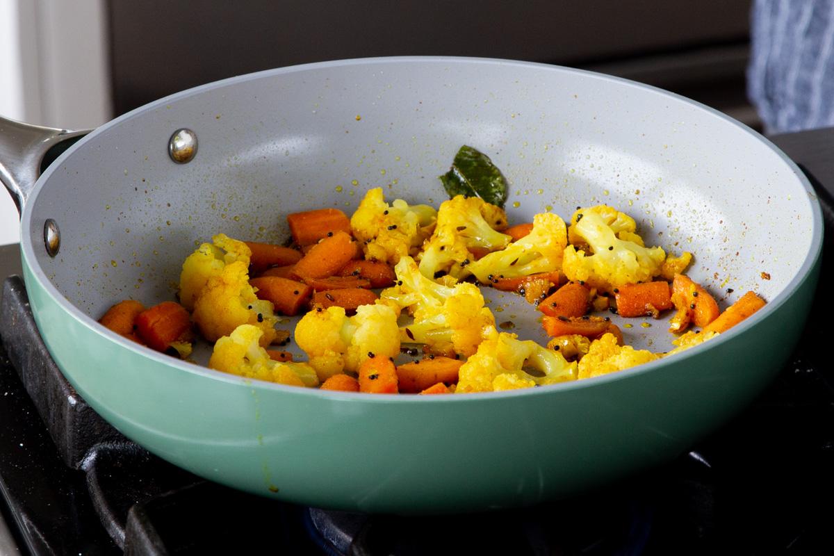 cauliflower and carrots in a baking pan with the tempering, after cooking