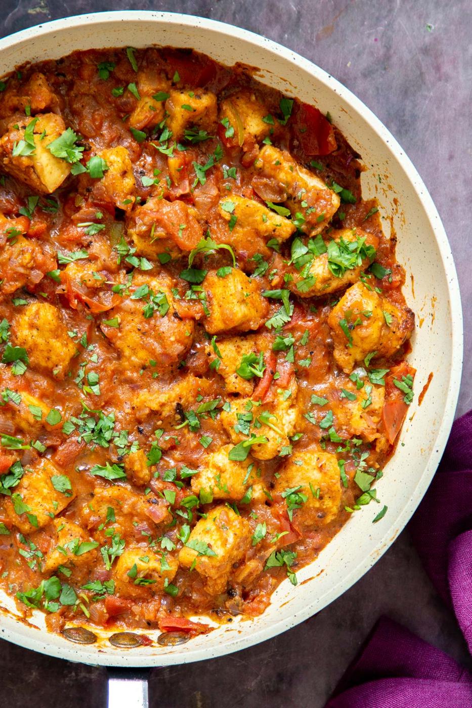 a pan with vegan Khada Masala Murg Curry with Baked Tofu sprinkled with chopped cilantro
