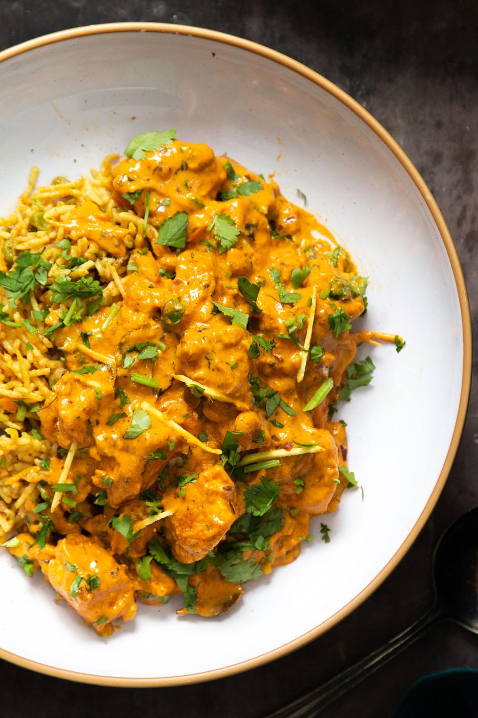 a serving of creamy vegan lasooni chicken curry on a white plate