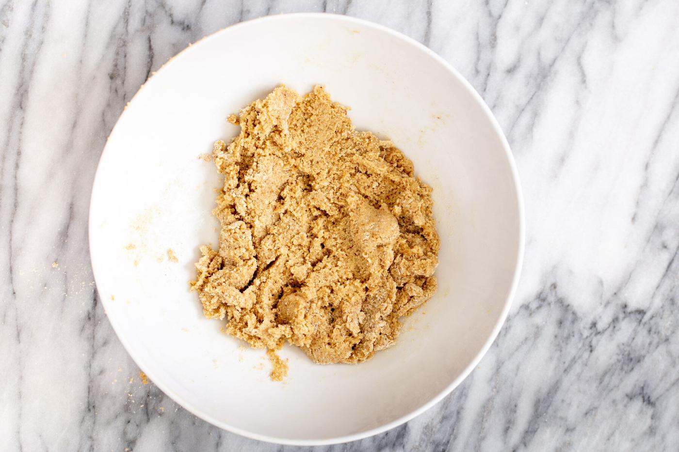 vegan cookie crust made from oatmeal and almond flour being mixed in a bowl