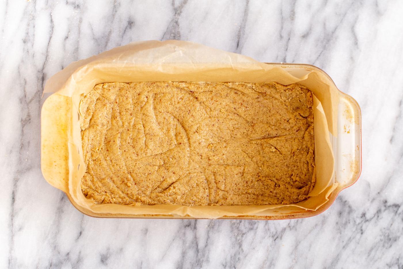 vegan cookie crust pressed in a pyrex loaf pan