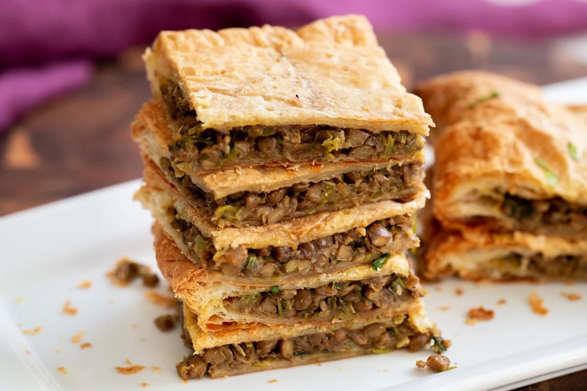stacked slices of vegan lentil pie with puff pastry