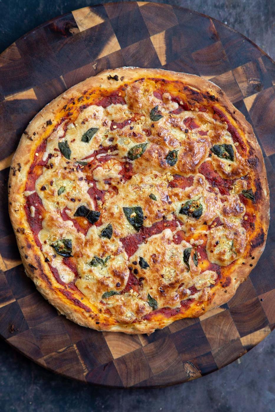 vegan mozzarella pizza on a chopping board