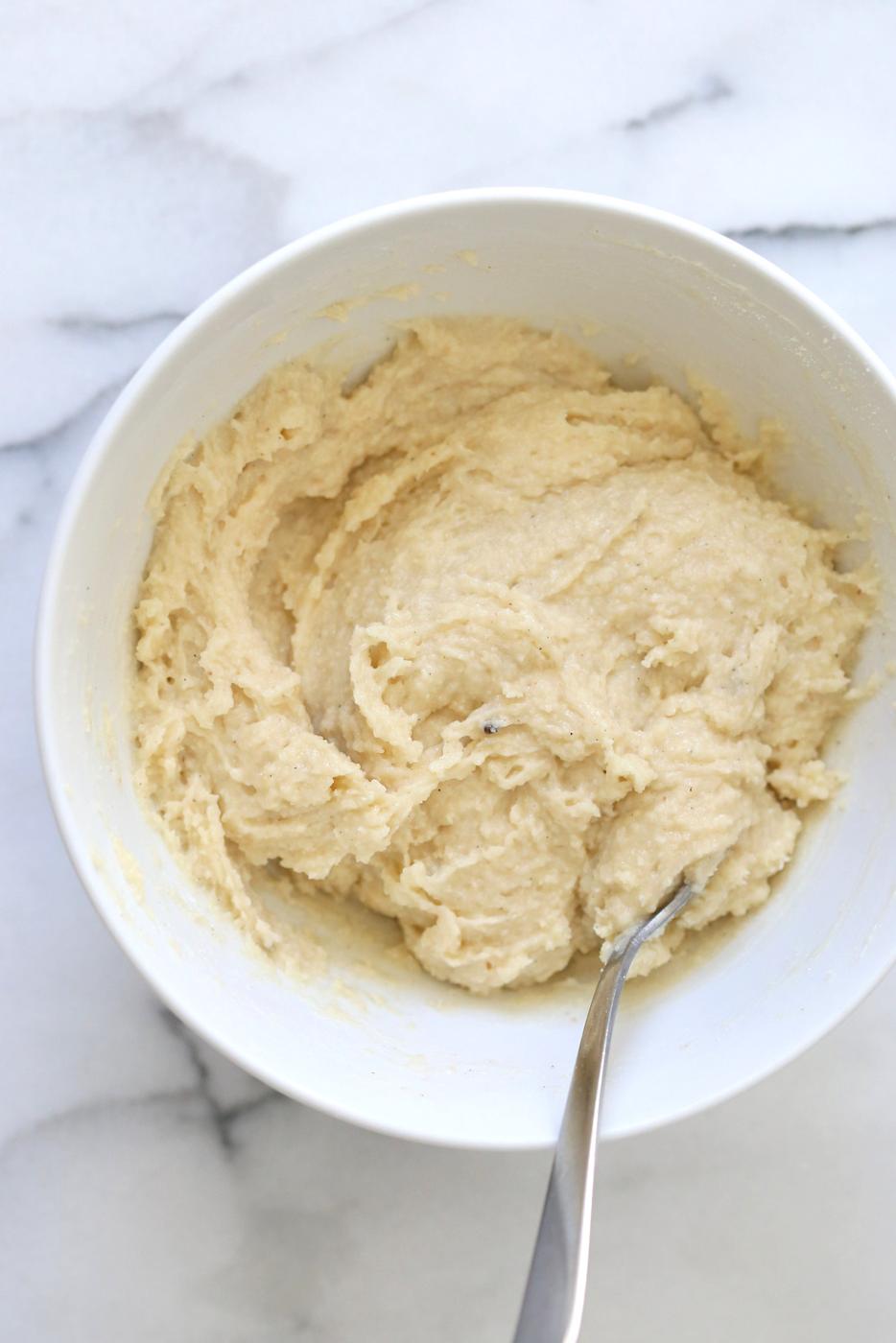 Making our Vegan Malai Burfi- Mixing almond flour, sugar, cardamom in a white bowl
