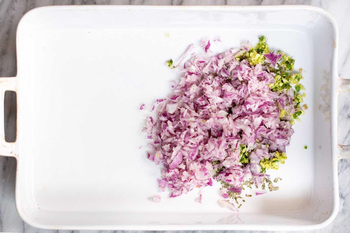 spices, garlic, ginger, and chilis in a baking pan with onion added