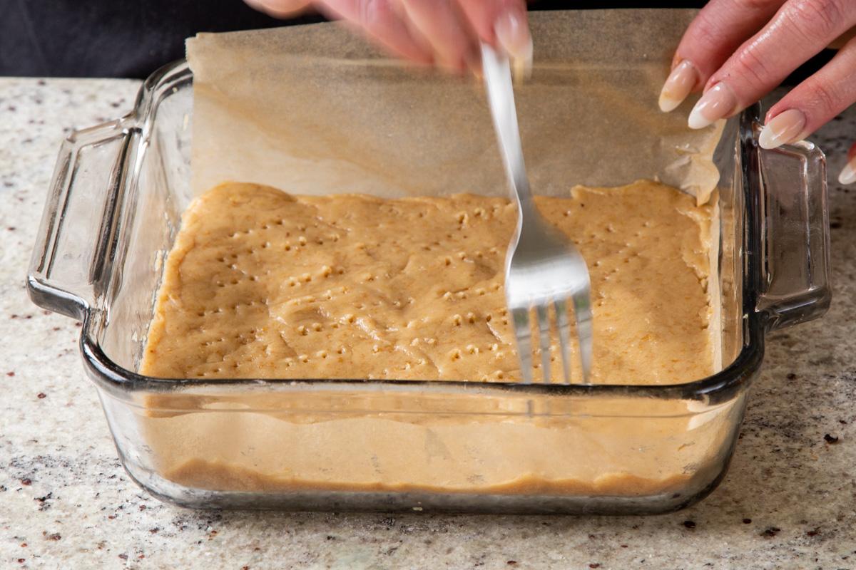 using a fork to pierce holes into the unbaked crust