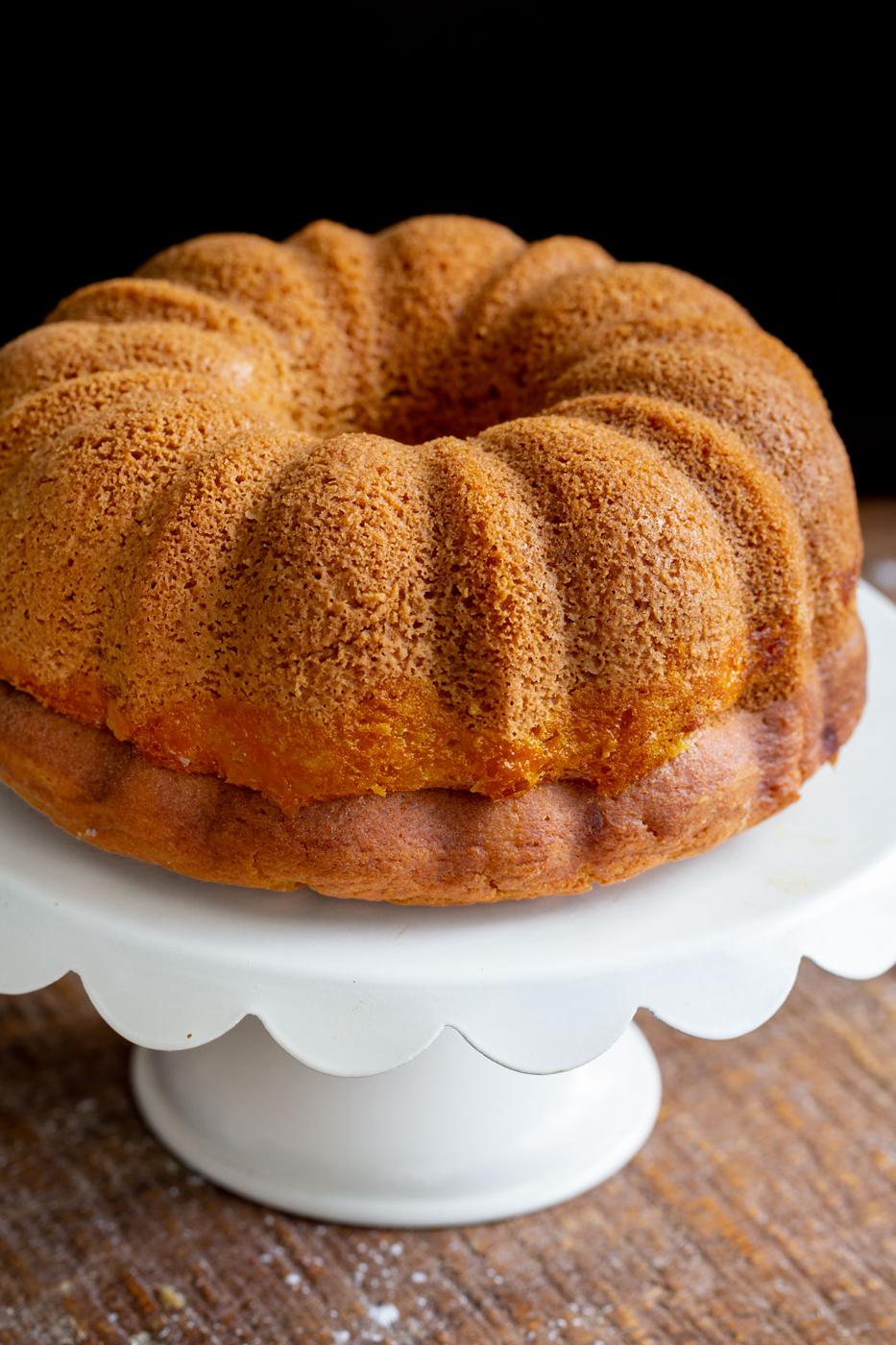 freshly baked mango bundt cake on a white cake stand