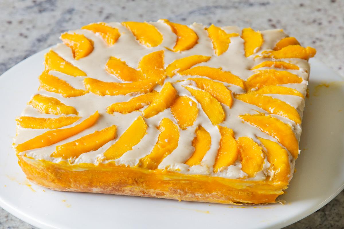 mango tiramisu on a cake stand, before slicing