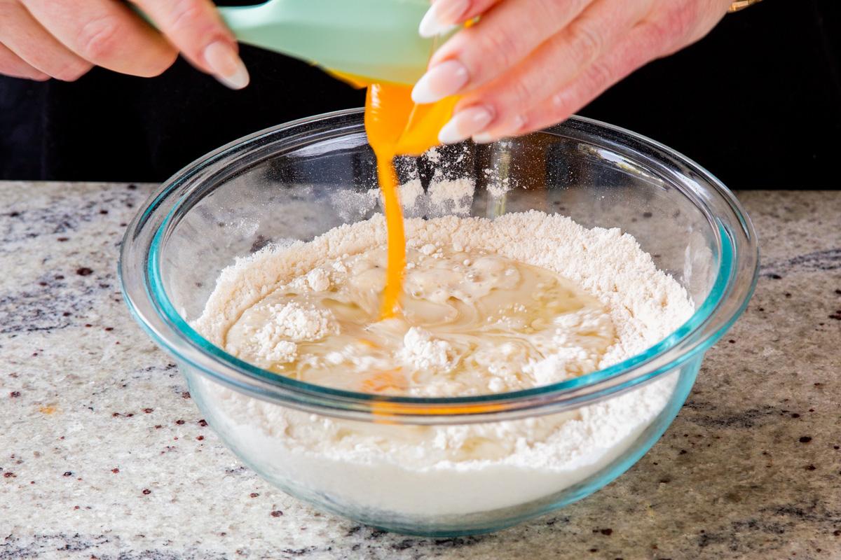 adding mango puree and other wet ingredients to the well in the center of the dry