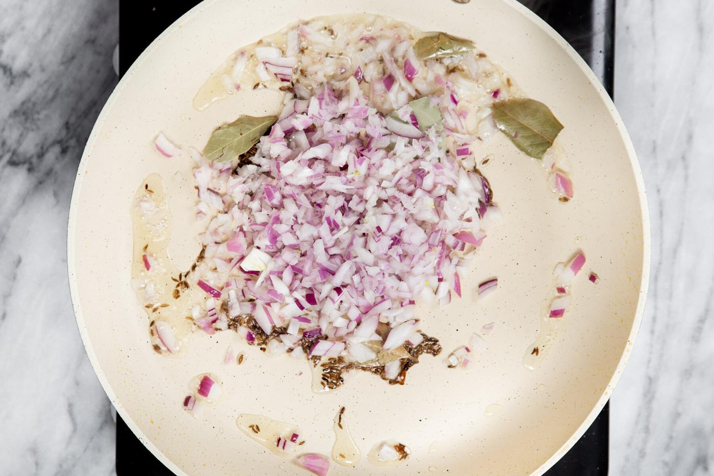 onion and spices sauteeing in a pan with oil