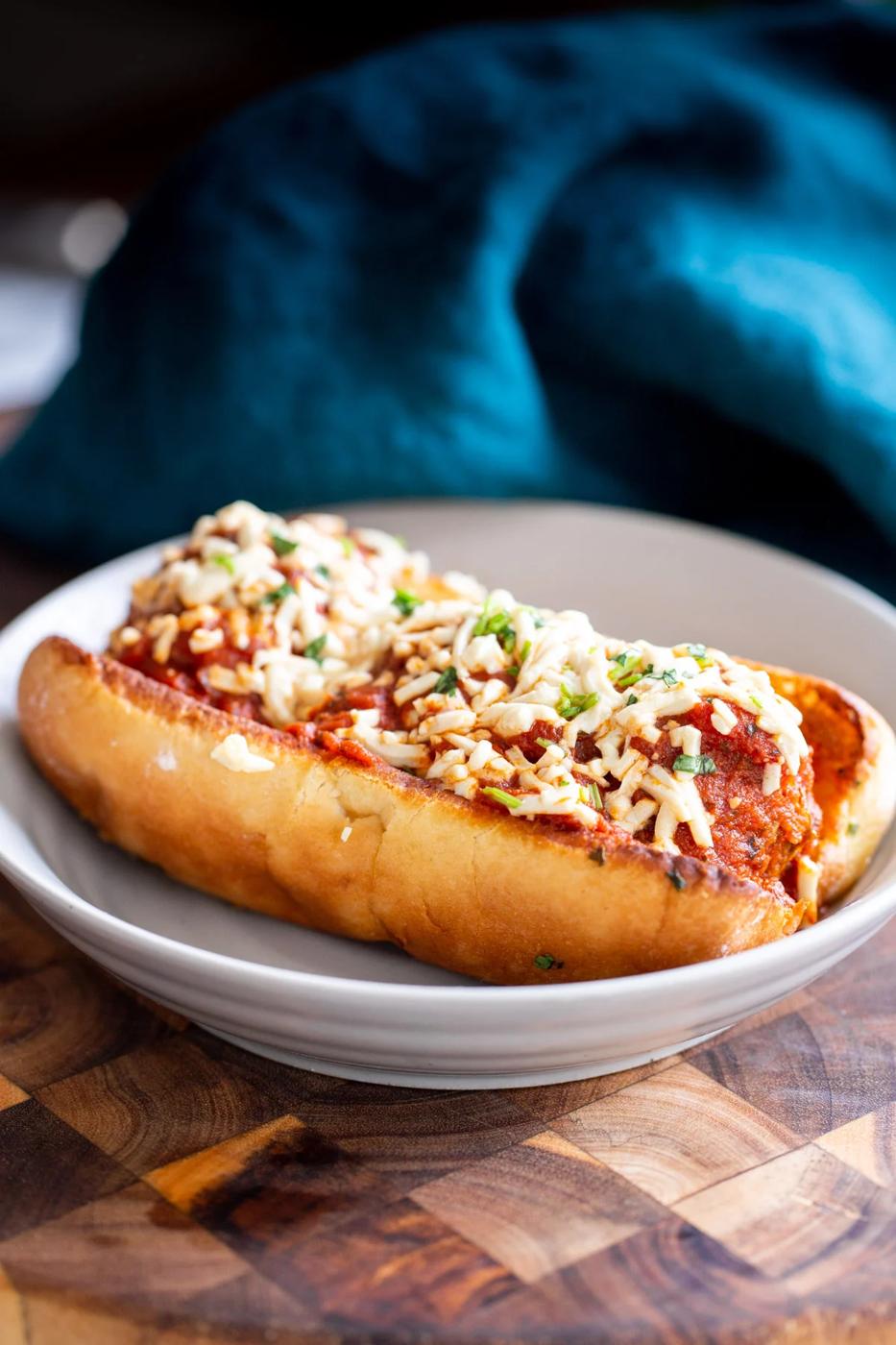 a vegan meatball sub made with lentil meatballs and topped with vegan cheese shreds
