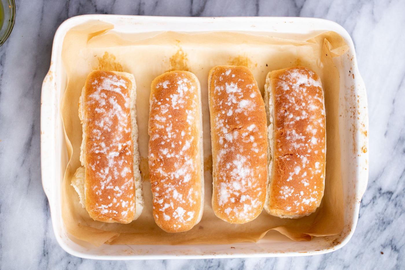 overhead shot of 4 baguette buns in a casserole dish