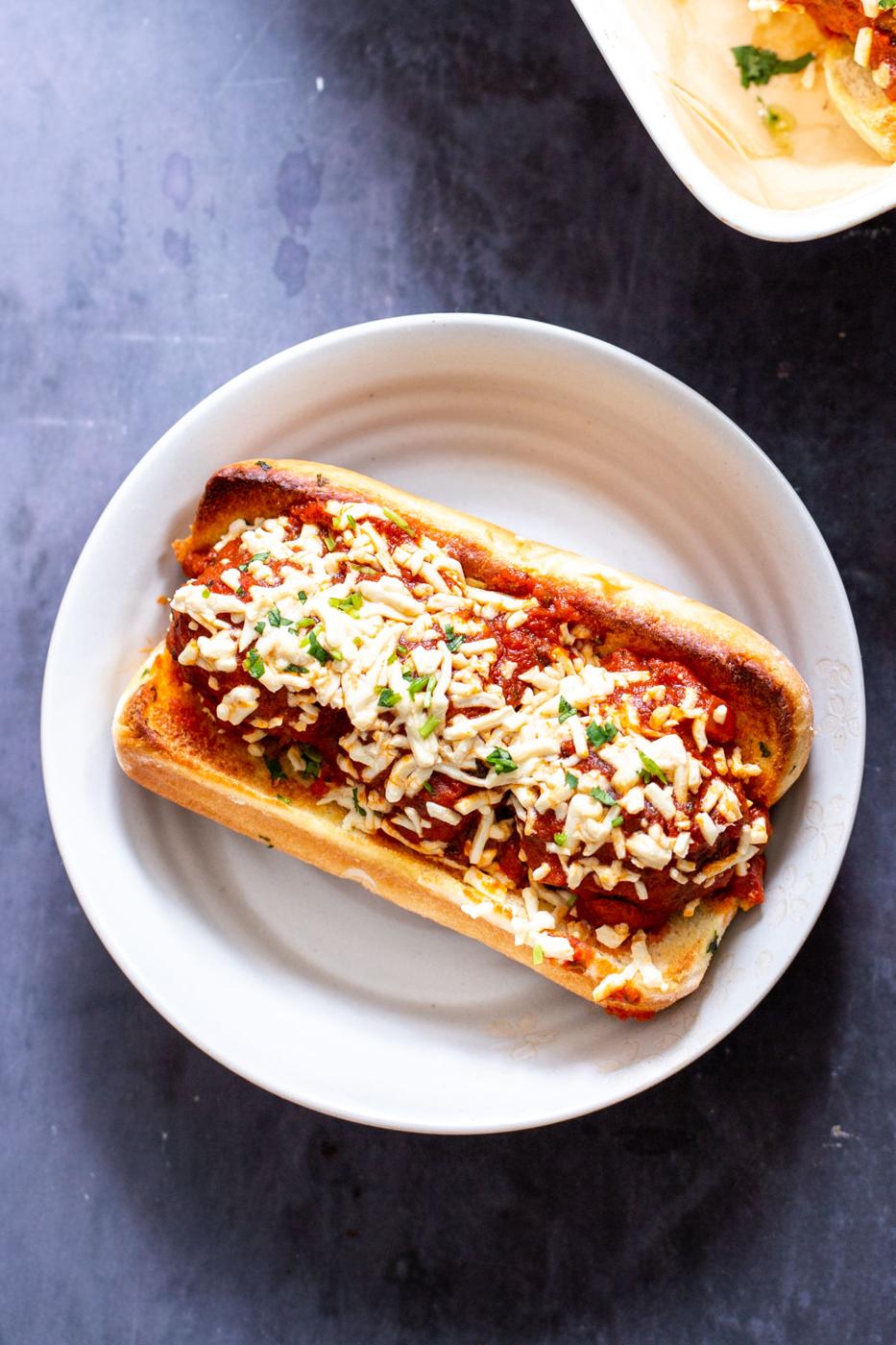 overhead shot of a vegan meatballs sub srinkled with vegan cheese shreds